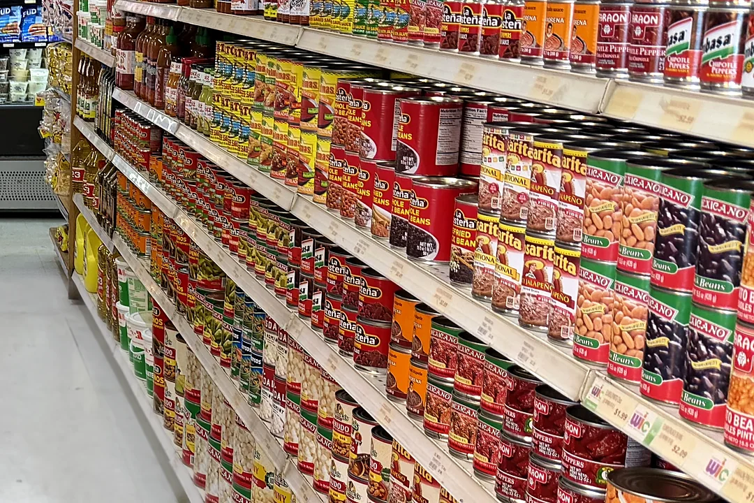 Un pasillo de abarrotes lleno de latas de frijoles, chiles, salsas y aceite