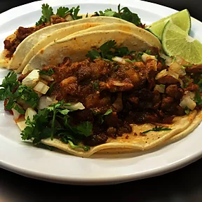 Dos tacos de al pastor con cebolla, cilantro y limón